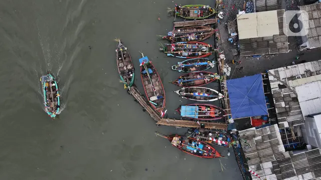 Nelayan tradisional Muara Angke melaksanakan ritual nadran pelarungan hasil bumi di perairan Jakarta, Minggu (26/11/2023). (merdeka.com/Imam Buhori)